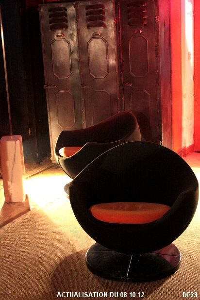 Paire de fauteuils Pod Egg Mars de Pierre Guariche vers 1970, accotoirs pleins, galb�s sur assise h�misph�rique; pi�tement tournant, recouvert d'un tissu noir, coussin orange.