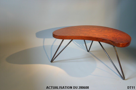 Petite table basse, vers 1950; pi�tement en fer cintr� laqu� noir, �pais plateau de bois exotique. Dans le go�t de Jean Roy�re.