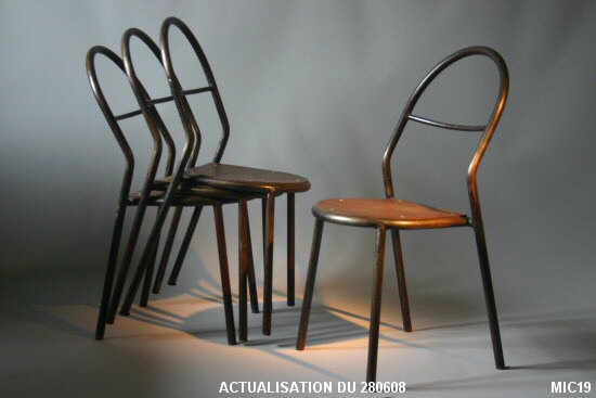 S�rie de six chaises en tube d�acier cintr�. Assise bois rivet�e. Belle harmonie des courbes pour ces chaises du d�but du 20e si�cle. Acier brut patin� noir, et bois multiplis.