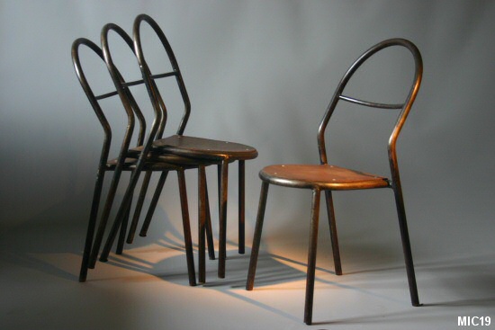 Série de six chaises en tube d’acier cintré. Assise bois rivetée. Belle harmonie des courbes pour ces chaises du début du 20e siècle. Acier brut patiné noir, et bois multiplis.