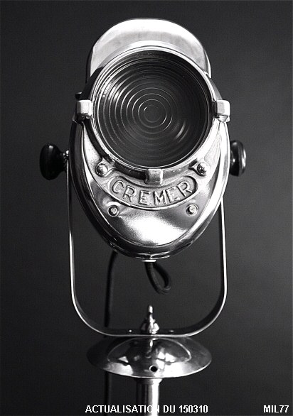 Projecteur de cin�ma de marque �&nbsp;CREMER&nbsp;�, vers 1940, puissance de 250 Watts, pied tripode, hauteur r�glable, bouton lat�ral en bak�lite. Acier poli, aluminium et lentille Fresnel.