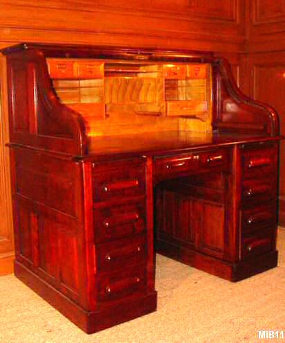 Bureau  cylindre de type dos d'ne de marque STANDARD vers 1930, rideau coulissant, 9 tiroirs, 2 tablettes, intrieur en bois fruitier, 6 tiroirs, nombreuses tagres. Corps acajou massif. Poignes bois.