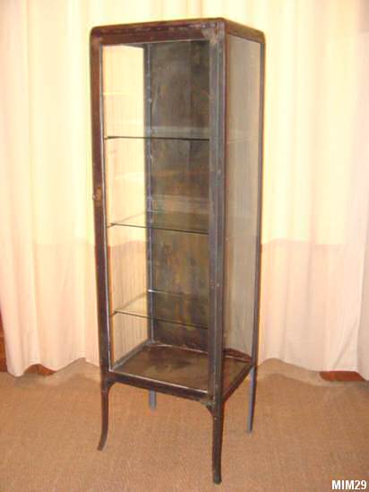 Petite armoire de mdecine vers 1920, jolis pieds, comprenant une porte et trois tagres en verre, mtal brut.