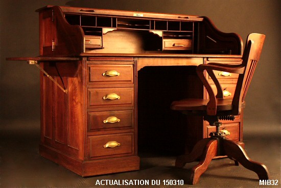Bureau � cylindre de type dos d'�ne vers 1930 de marque FRANCO AMERICAIN, rideau coulissant, joues articul�es, 8 tiroirs, 2 tablettes, int�rieur 2 tiroirs, tablette repliable sur c�t� gauche, nombreuses �tag�res. Corps noyer massif. Poign�es fonte.