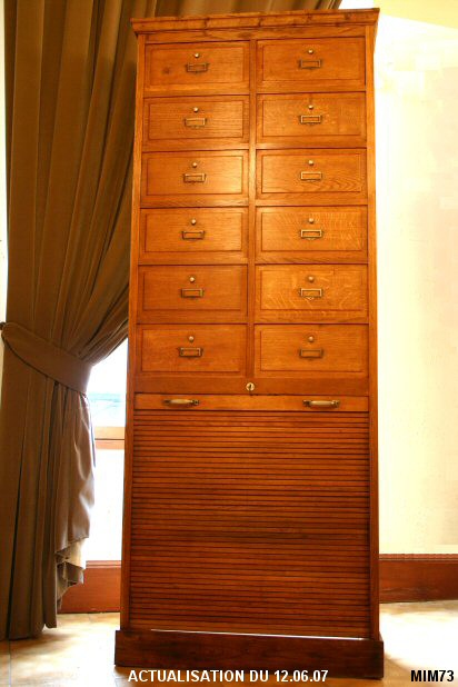 Meuble de classement vers 1950, style cartonnier, 12 portillons, un rideau coulissant, �tag�res, ch�ne clair.