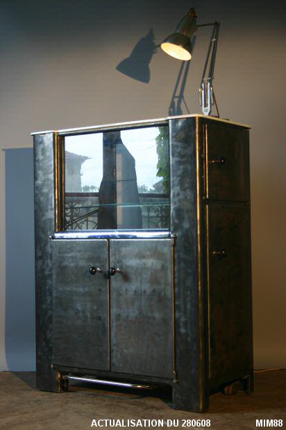 Meuble � syst�mes vers 1950, de marque&nbsp;EMDA cabinet dentaire, double face, 8 vantaux, p�dales pour ouverture du rangement central recto&nbsp;/ verso, rangements lat�raux. Acier brut bross�, poign�es en bak�lite, �tag�res en verre et plateau en opaline blanche. Id�al pour salle de bain ou bar de salon.