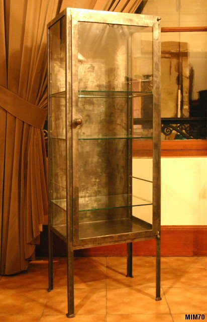 Petite armoire de mdecine vers 1920, jolis pieds, comprenant une porte et trois tagres en verre, mtal brut.